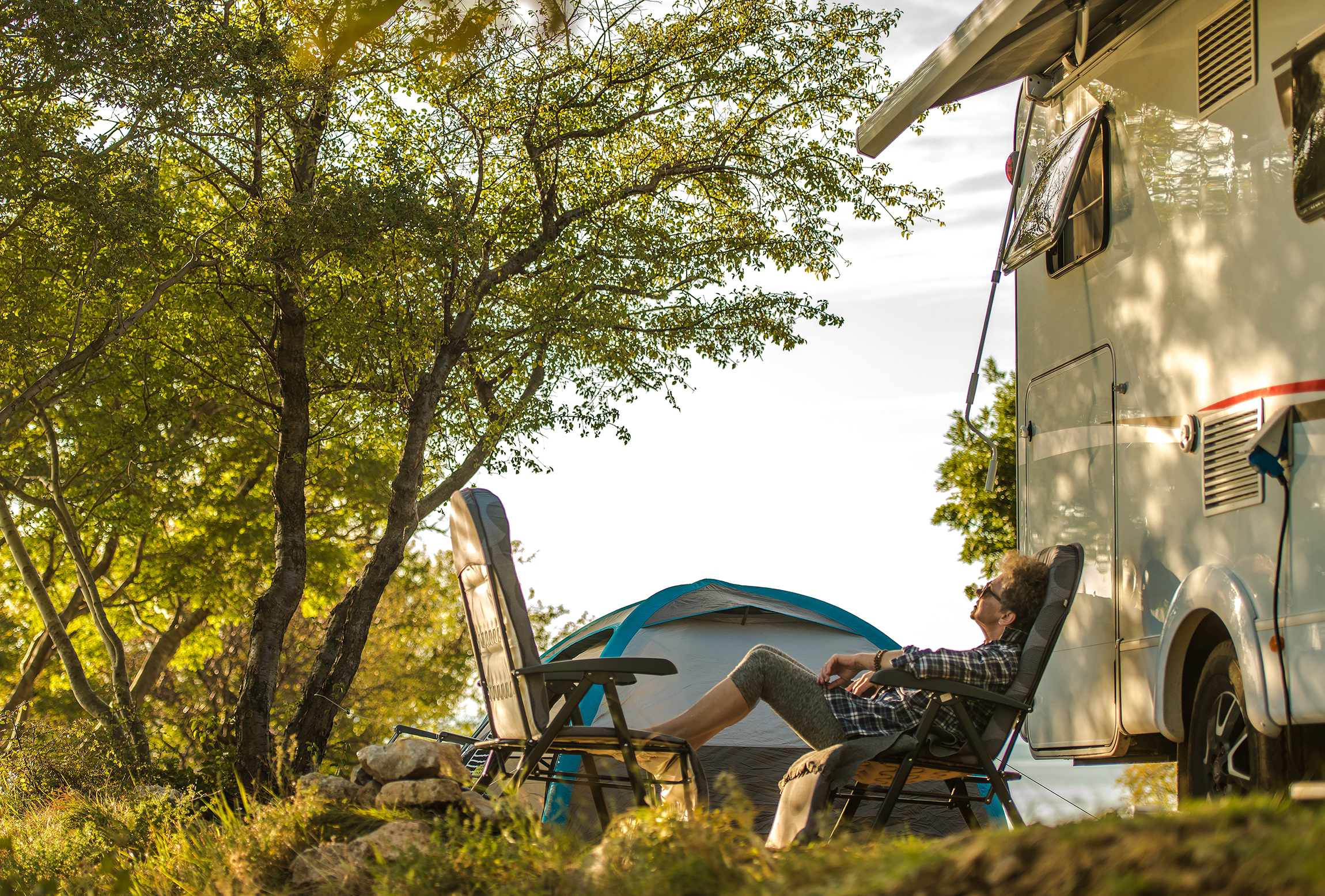 person relaxing outside rv on road trip at Texas RV park